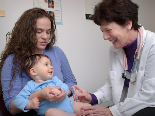 doctor gives shot to baby