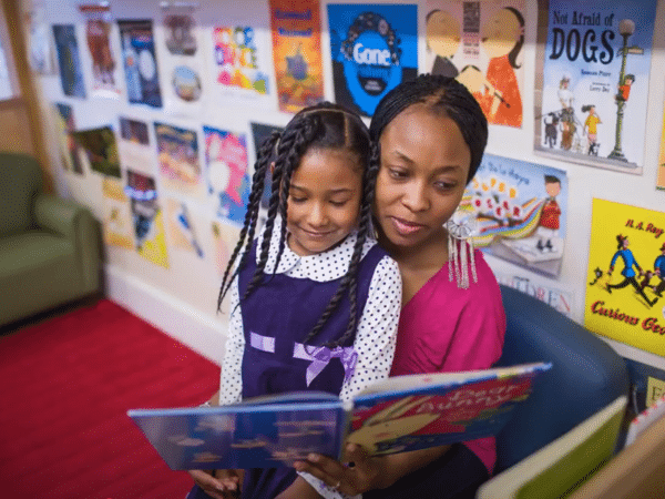 Child Care Provider Reading Book to Toddler