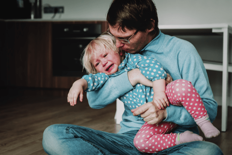 man comforting crying toddler