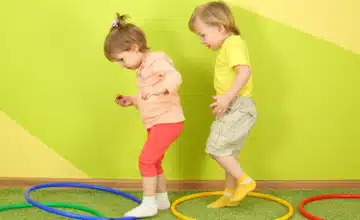 two toddlers jumping through hoops