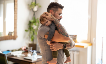 Man with tattoos holding his toddler