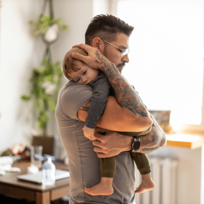 Man with tattoos holding his toddler