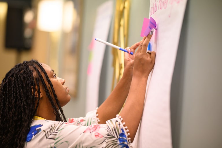 A conference attendee writing on a board