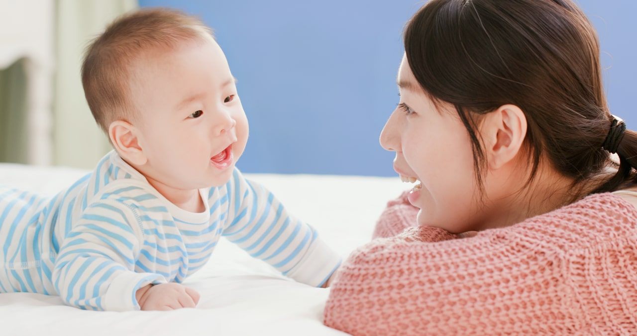 Mother talking to her infant during tummy time