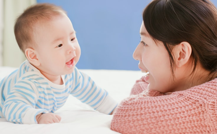 Mother talking to her infant during tummy time