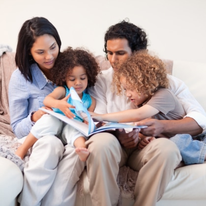 babyfam, love,play,young women,storytelling,book,happy,boys,couch,affecti Young family on the sofa looking at the photo album together