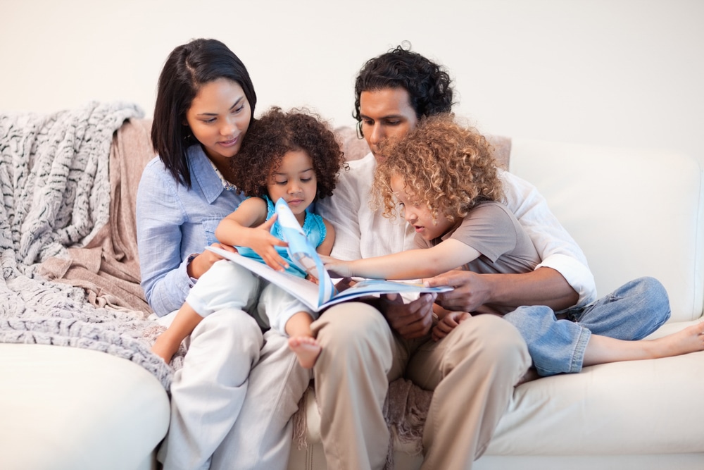 babyfam, love,play,young women,storytelling,book,happy,boys,couch,affecti Young family on the sofa looking at the photo album together