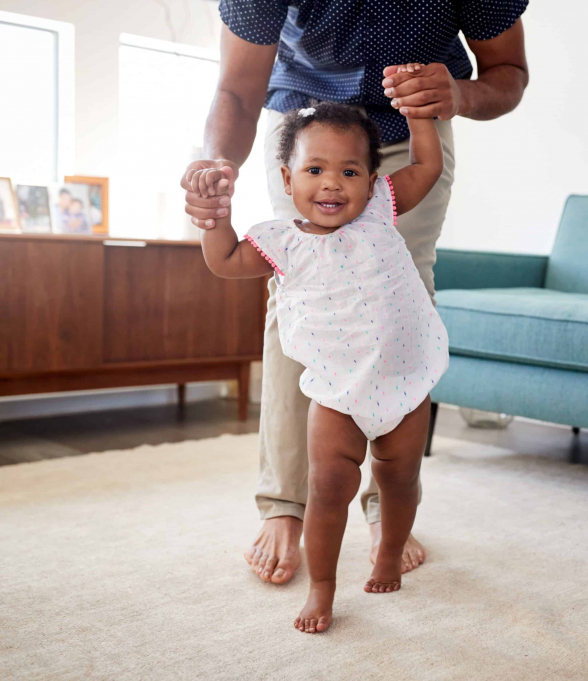 Father Holding Baby by Hands While Walking